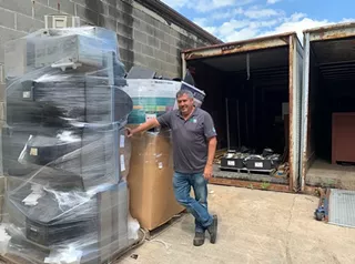 Brian Dickerson at the loading dock with pallets of items to be recycled.
